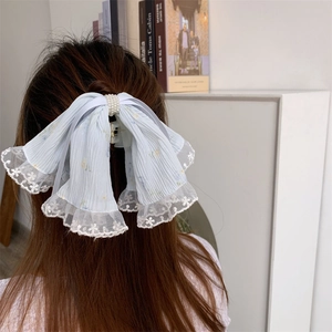 Detail of light blue lace bow hair claw with pearls and floral embroidery decor