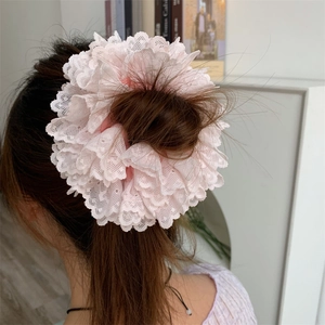 Close-up of pink layered lace scrunchie worn on a bun hairstyle for an elegant look