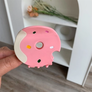 Detailed view of a cute pink donut-shaped hair claw clip held by hand for scale