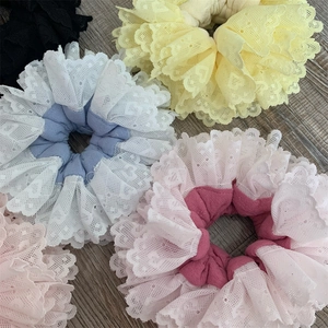 Detailed view of layered lace scrunchies with intricate mesh textures and ruffled edges