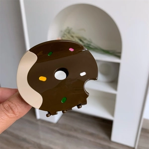Detail view of donut hair claw clip with colorful sprinkles and chocolate glaze texture