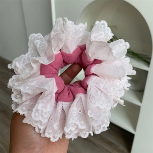 Detail of pink and white layered lace scrunchie with delicate scalloped edges and frills