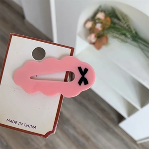 Détail d'une barrette rose à motif de nœud imprimé sur carte pour jeunes filles