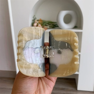 Détails de la grande pince à cheveux en acétate avec une texture marbrée élégante