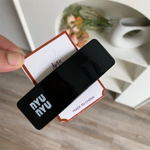 Minimalist black hair clip with white letter logo on white display card packaging