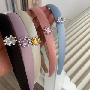 Détail des cristaux de zircon colorés et strass sur des serre-têtes élégants en tissu