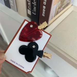 Close-up of playing card shaped acetate hair clips with heart and clover patterns