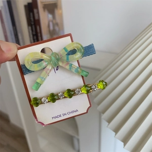 Détail du nœud rayé vert et épingle à cheveux sertie de gemmes florales pour fille