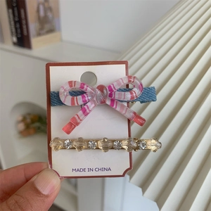 Gros plan d'un ensemble de barrettes à nœud avec strass et perles sur carton
