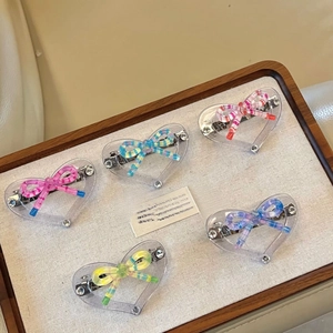 Detailed view of 5-piece heart acrylic hair clips with colorful striped bow decorations