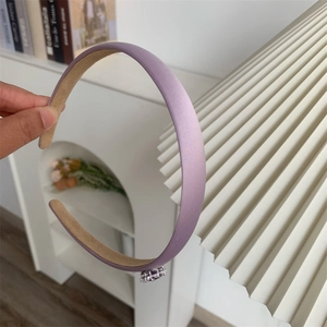 Détail d'un serre-tête en satin lilas orné d'une boucle délicate en strass argentés
