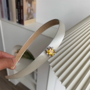 Serre-tête élégant en satin beige orné d'un zircon jaune étincelant et de cristaux fins