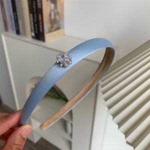 Gros plan sur le serre-tête en satin bleu clair orné d'un délicat zircon flocon de neige