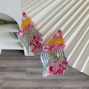 Detail of seashell cellulose acetate hair claw clips with marble texture and blue wave accents