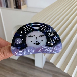 Detailed macro view of the moon and stars pattern with rhinestones on the acetate hair claw