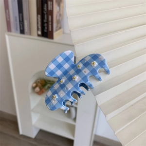 Dettaglio della molletta a scacchi blu con fiori 3D e piccoli strass luminosi