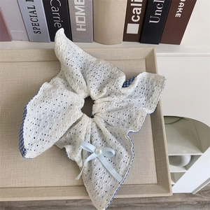 Elegant white lace bow scrunchie with blue plaid edge and pearl detail on tray