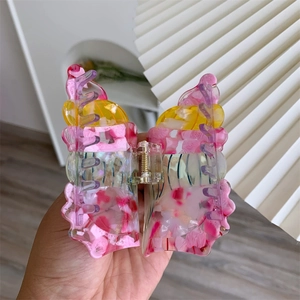 Detail showing marble textured colorful acetate shark hair claw with gold spring mechanism