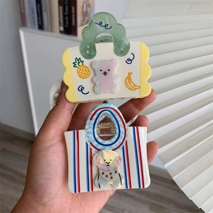 Detail of cute acetate hair claw clips featuring bear and puppy handbag designs