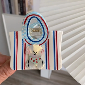 Detail of bear handbag hair claw with cream acrylic, red stripes and white puppy design