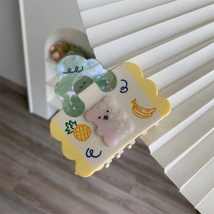 Detail of bear shaped hair claw with pineapple and banana patterns and mini rhinestones