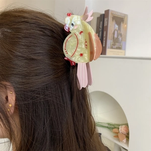 Detailed view of creative parrot-shaped acetate hair claw clip worn on hair