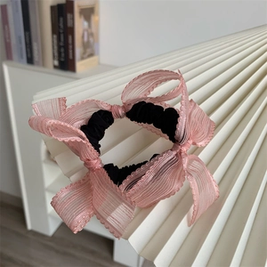 Detailed view of pink lace ribbon bow on a black elastic scrunchie for women