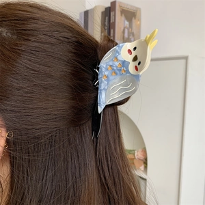 Creative parrot shaped blue marble acetate hair claw clip worn on a model in a home setting
