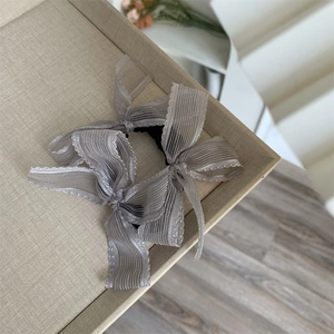 Detailed close-up of light gray organza double bow hair scrunchie with high elastic band