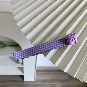 Pince à cheveux à carreaux violets avec rose en ruban sur fond crème minimaliste