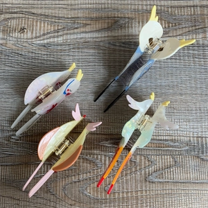 Detailed set of colorful bird-shaped acetate hair claws including parrot and swallow designs