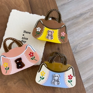 Détail de pinces à cheveux en forme de sac avec oursons et motifs floraux
