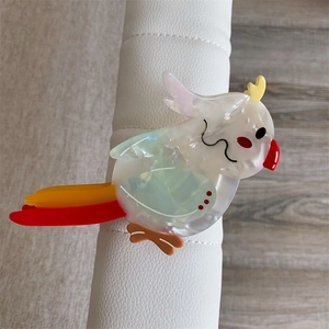 Macro detail of parrot-shaped hair claw clip made from colorful high-quality acetate