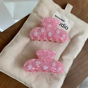 Pinces à cheveux en acétate rose avec fleurs de perles sur fond en bois élégant