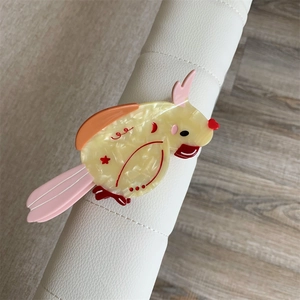 Detail view of a colorful parrot acetate hair claw clip showing vibrant marble textures