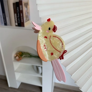 Detailed view of the yellow marble patterned acetate parrot hair claw clip with colorful accents
