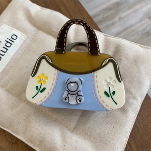 Détail de la pince à cheveux en acétate forme sac à main avec ours violet et fleurs strass