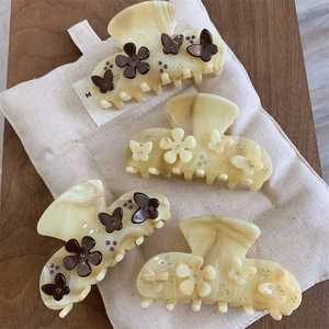 Lush acetate hair claw set with marble cream texture and 3D floral butterfly accents