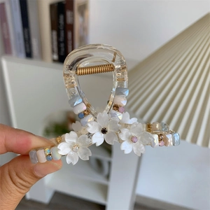 Detail of sweet floral hair claw clip with colorful crystal beads and shell-like petals