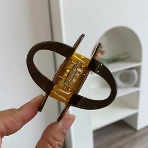 Détail de la pince à cheveux en acétate avec ressort métallique et finition polie