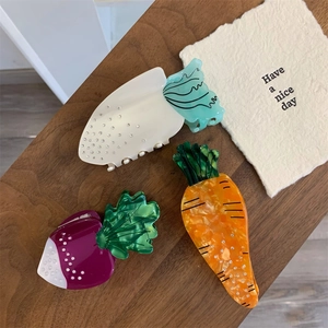 Pinces à cheveux chic en acétate en forme de légumes avec strass sur une table en bois