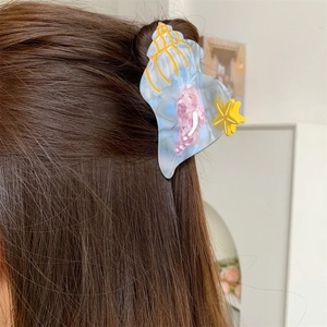 Medium acetate conch hair claw clip in pastel blue with marble texture and starfish detail