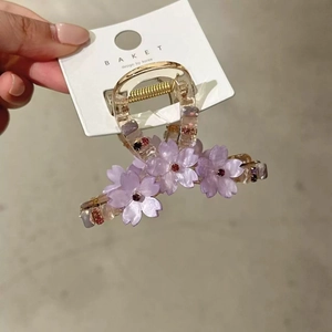Elegant purple flower hair claw clip with crystal center and a translucent petal design
