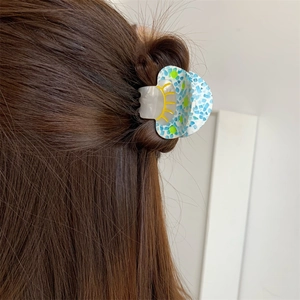 Detail view of colorful acetate mushroom hair claw clip on semi-tied hairstyle