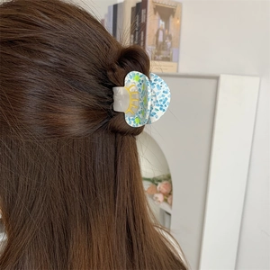 Blue mosaic acetate mushroom hair claw clip shown on brunette hair in a home setting