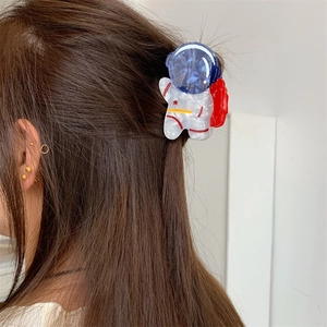 Détail de la pince à cheveux astronaute en acétate sur cheveux bruns avec motif planétaire