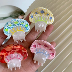 Detailed close-up of colorful mushroom hair claws showing mosaic acetate texture and teeth
