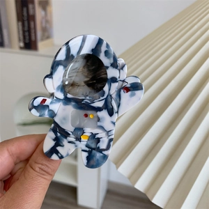 Détail macro d'une pince à cheveux astronaute en acétate avec marbrures bleues et blanches