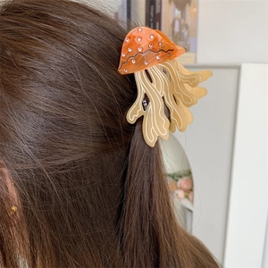 Jellyfish-shaped acetate hair claw with orange finish and sparkling rhinestones for women