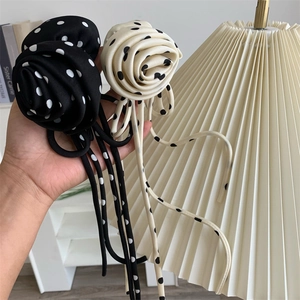 Détail de pinces à cheveux roses en tissu à pois avec de longs rubans de soie élégants